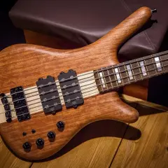 Guitare basse en bois naturel, prête pour un solo de basse endiablé.