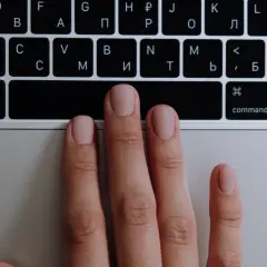 Main gauche sur un clavier, prête à apprendre à jouer du clavier. Les doigts effleurent les touches.
