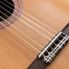 Guitare classique avec ses cordes en nylon, contrastant avec une guitare acoustique. Le bois clair et la rosace ornée invitent à la mélodie.