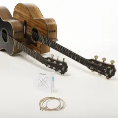 Deux guitares acoustiques, une noire et une en bois naturel, prêtes à produire le son de la guitare. Un jeu de cordes D'Addario est posé devant.