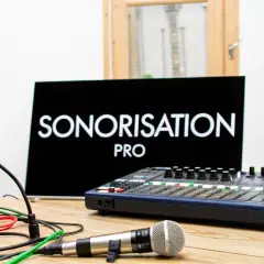 Studio d'enregistrement avec enceintes, console de mixage, micro et écran affichant "SONORISATION PRO". Idéal pour un **sono groupe musique**.