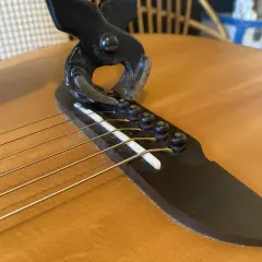 Pince coupante sur le chevalet d'une guitare, illustrant un problème de prise jack.
