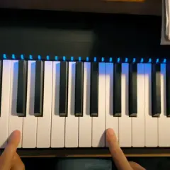 Les doigts effleurent les touches d'un **dièse clavier** illuminé de bleu, prêt à jouer une mélodie.