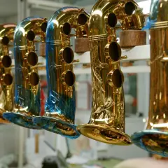 Une rangée de saxophones dorés, certains ornés de gravures, prêts à raconter leur histoire musicale.