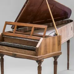 Un clavecin, membre de la famille des instruments à clavier, avec son couvercle ouvert et son pupitre.
