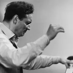 Un pianiste connu, le regard concentré, ses mains effleurent les touches du piano, capturant l'essence de la musique.