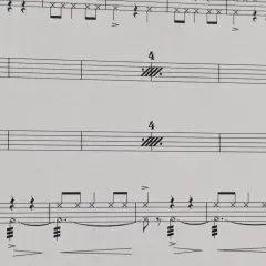 Partitions musicales avec des notes de batterie et des indications de tempo. Le symbole de répétition musique est présent, suggérant une section à rejouer.