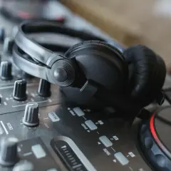 Casque DJ sur une table de mixage, prêt pour le mix. Les boutons et faders, pré et post fader, sont visibles.