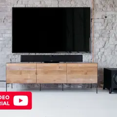 Un salon moderne avec TV, barre de son et caisson de basse. Découvrez où placer caisson de basse pour un son optimal.