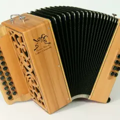 Un accordéon instrument à vent en bois clair, avec des boutons noirs et un soufflet noir. Le logo "Loffet" est visible.