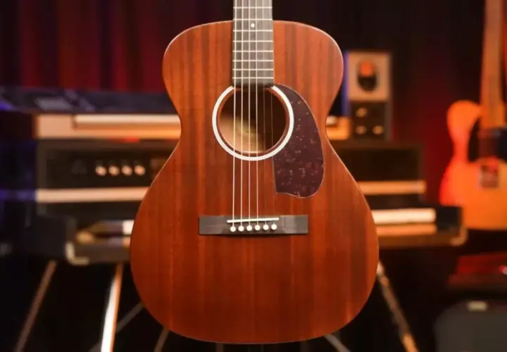 Guitare folk en bois massif, finition acajou, prête pour une session d'enregistrement.