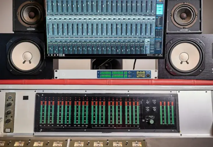 Studio d'enregistrement avec enceintes Yamaha, écran affichant une console numérique et un transducteur sonore.