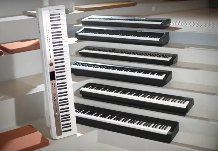 Une rangée de claviers de piano numérique ou acoustique, certains blancs, d'autres noirs, disposés en escalier.