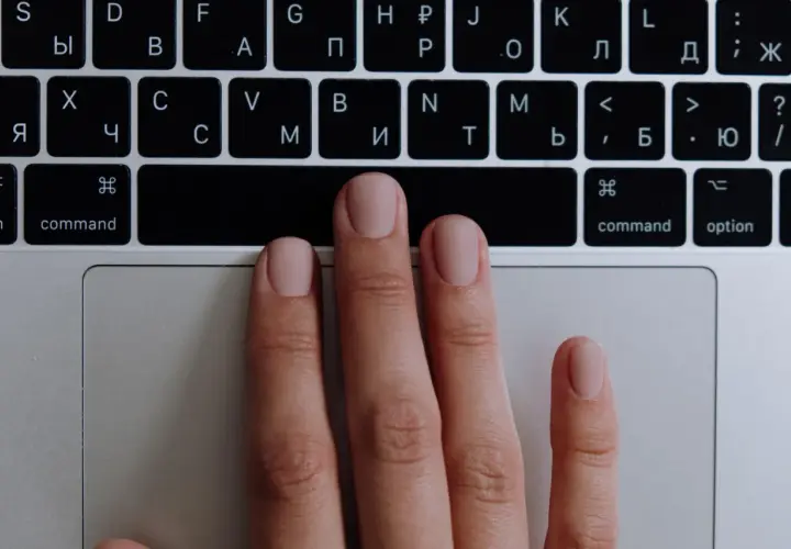 Main gauche sur un clavier, prête à apprendre à jouer du clavier. Les doigts effleurent les touches.