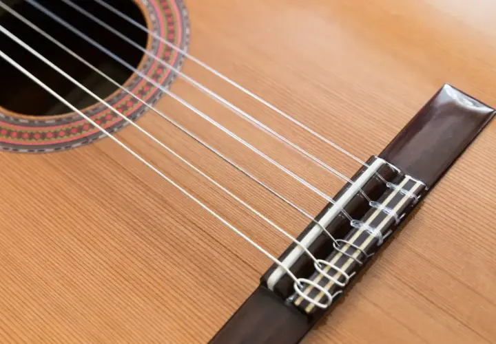Guitare classique avec ses cordes en nylon, contrastant avec une guitare acoustique. Le bois clair et la rosace ornée invitent à la mélodie.
