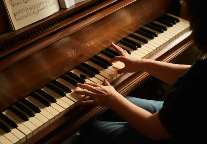 Mains sur les touches d'un piano, une partition ouverte. Le son du fa# résonne.