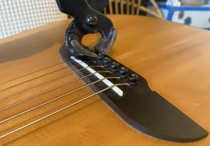 Pince coupante sur le chevalet d'une guitare, illustrant un problème de prise jack.