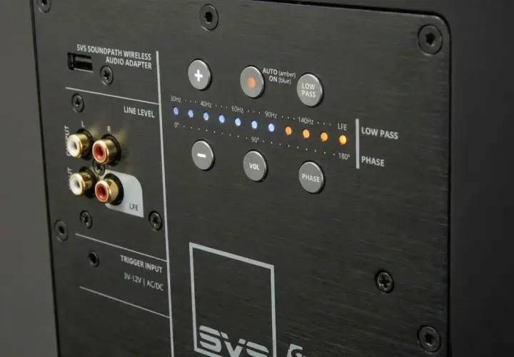 Panneau arrière d'un caisson de basse SVS. Réglage du caisson de basse avec connecteurs RCA, commandes de volume, phase, et indicateurs de fréquence.