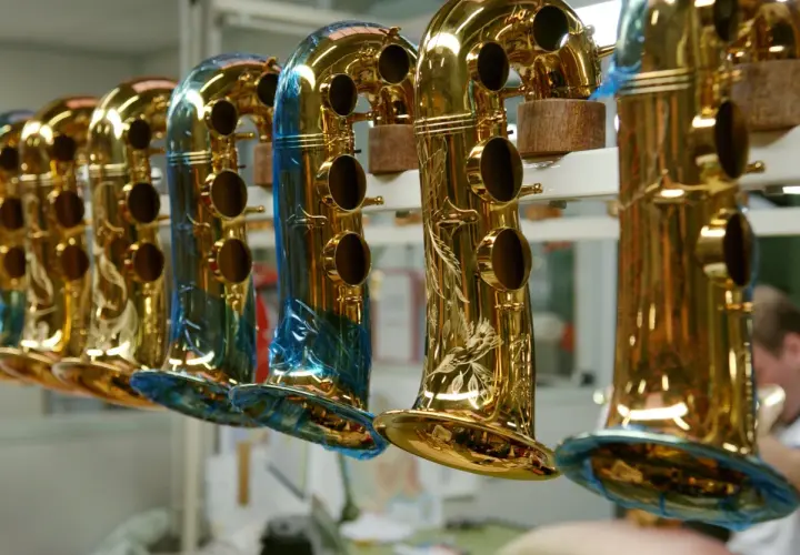 Une rangée de saxophones dorés, certains ornés de gravures, prêts à raconter leur histoire musicale.