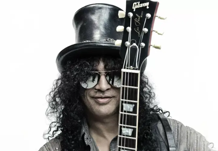 Le guitariste connu Slash, avec son chapeau haut-de-forme et ses lunettes de soleil, tient sa Gibson Les Paul.