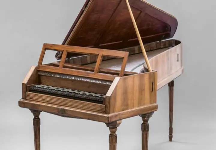 Un clavecin, membre de la famille des instruments à clavier, avec son couvercle ouvert et son pupitre.