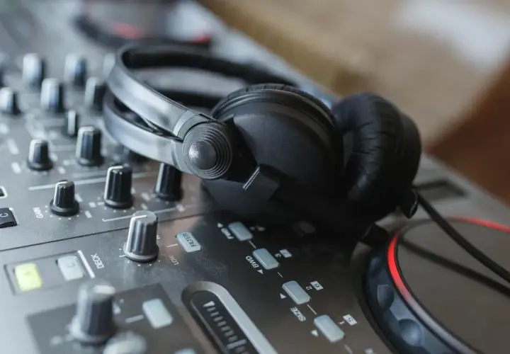 Casque DJ sur une table de mixage, prêt pour le mix. Les boutons et faders, pré et post fader, sont visibles.