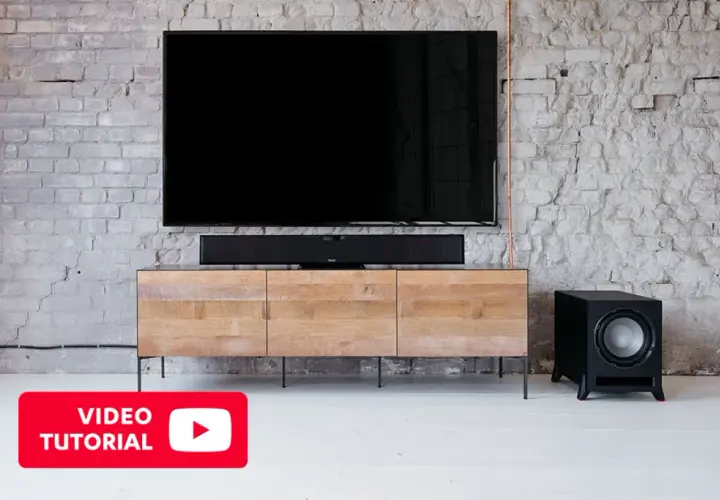 Un salon moderne avec TV, barre de son et caisson de basse. Découvrez où placer caisson de basse pour un son optimal.