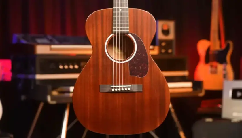Guitare folk en bois massif, finition acajou, prête pour une session d'enregistrement.