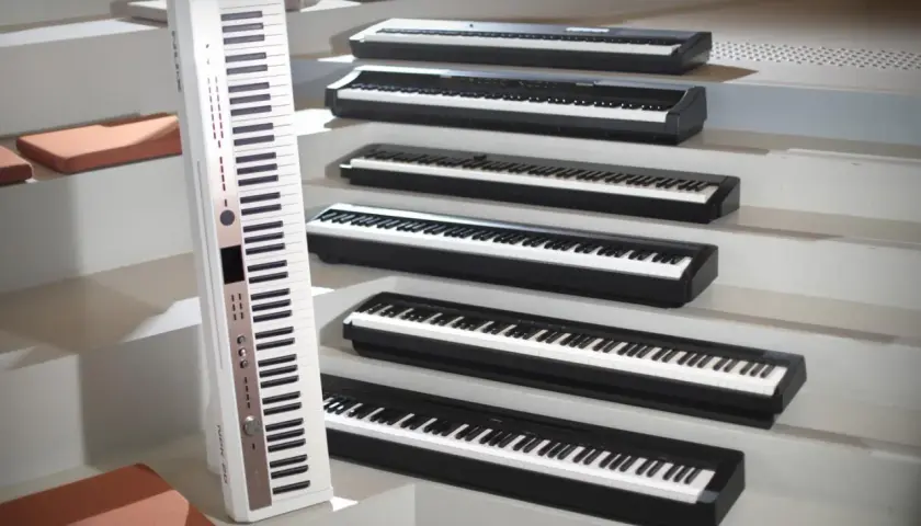 Une rangée de claviers de piano numérique ou acoustique, certains blancs, d'autres noirs, disposés en escalier.