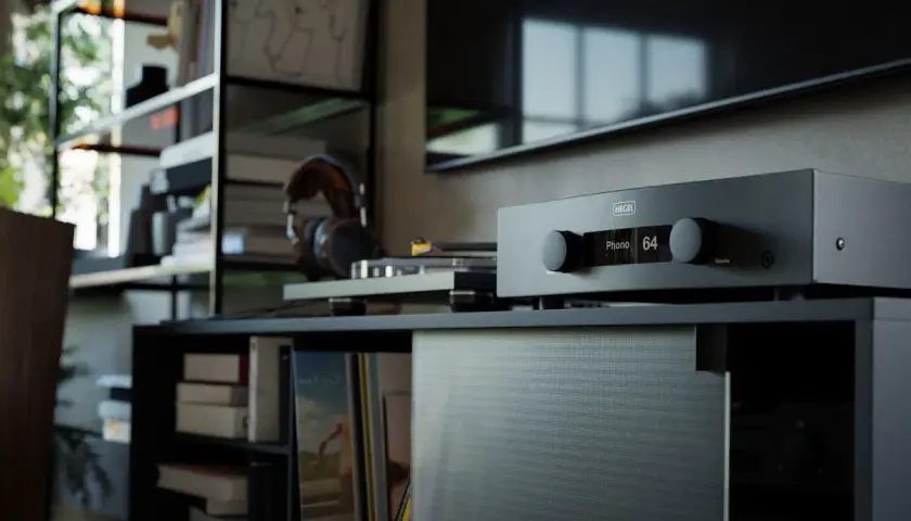 Amplificateur Hegel avec réglage du **damping factor** à 64. Casque et platine vinyle à proximité, dans un salon cosy.