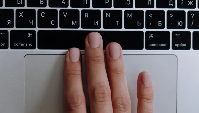 Main gauche sur un clavier, prête à apprendre à jouer du clavier. Les doigts effleurent les touches.