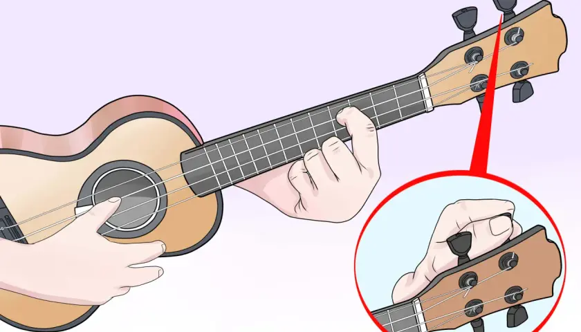 Main d'un musicien ajustant les mécaniques pour l'ukulele accordage. Gros plan sur la tête de l'instrument.