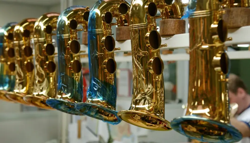 Une rangée de saxophones dorés, certains ornés de gravures, prêts à raconter leur histoire musicale.