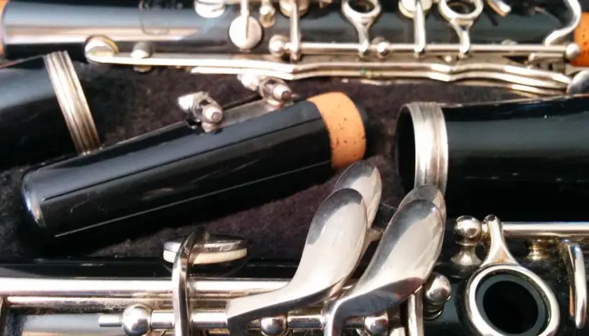 Détail d'une clarinette dans son étui, prête pour apprendre à jouer de cet instrument. Les clés argentées et le corps noir promettent de belles mélodies.