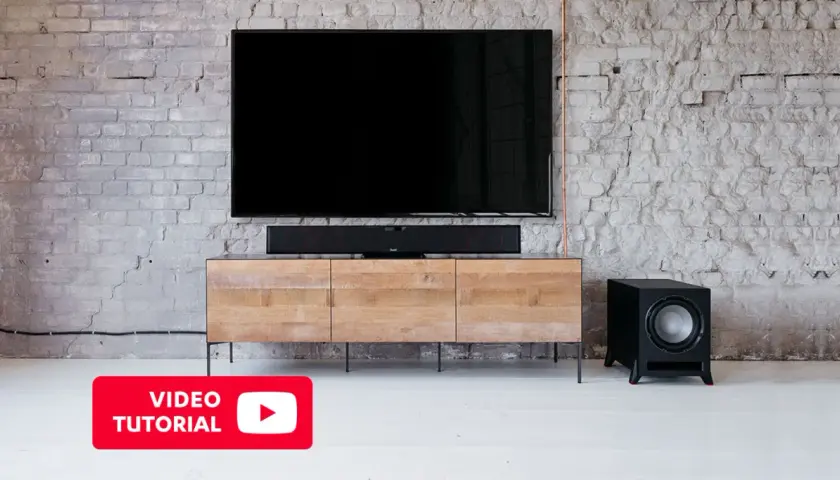 Un salon moderne avec TV, barre de son et caisson de basse. Découvrez où placer caisson de basse pour un son optimal.