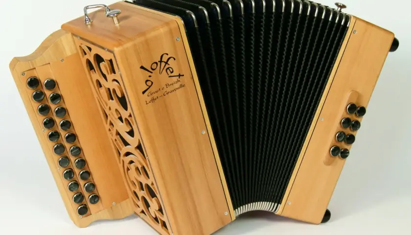 Un accordéon instrument à vent en bois clair, avec des boutons noirs et un soufflet noir. Le logo "Loffet" est visible.