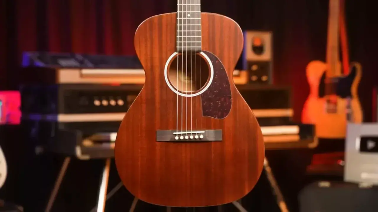 Guitare folk en bois massif, finition acajou, prête pour une session d'enregistrement.
