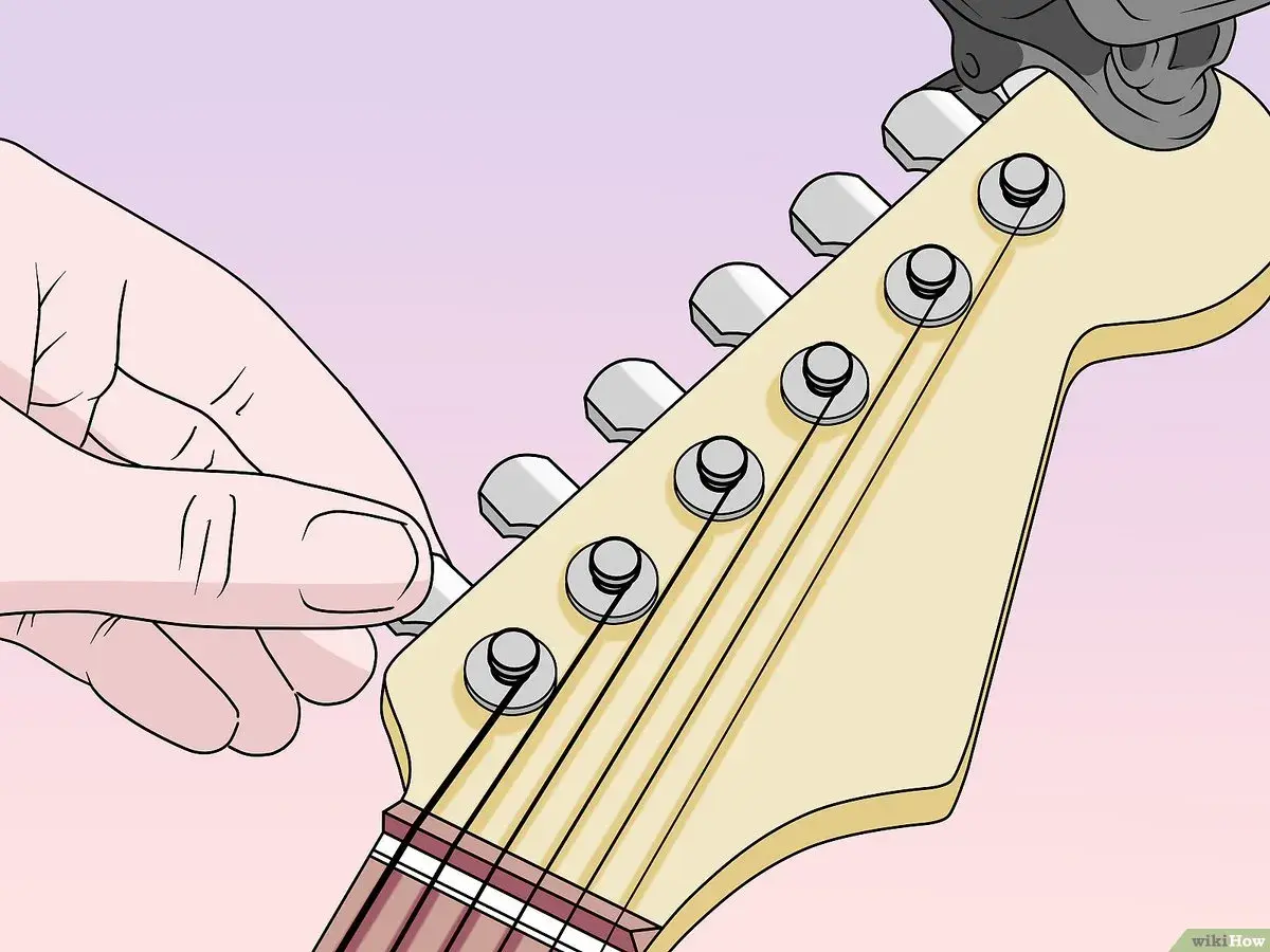 Main d'un guitariste ajustant l'accordage d'une guitare 7 cordes.