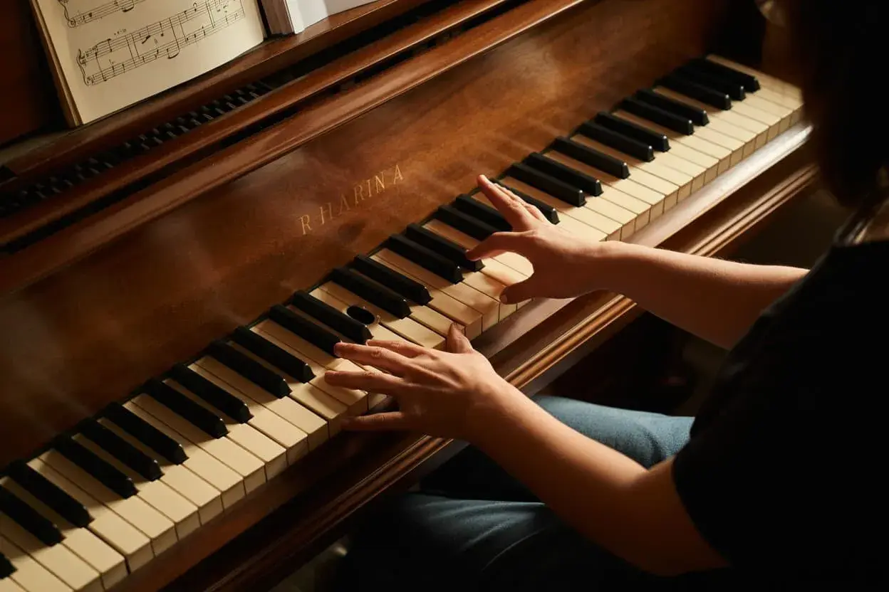 Mains sur les touches d'un piano, une partition ouverte. Le son du fa# résonne.