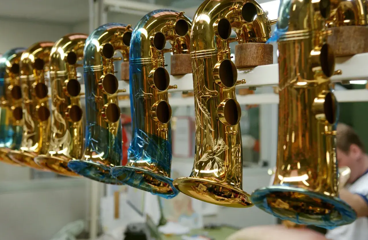 Une rangée de saxophones dorés, certains ornés de gravures, prêts à raconter leur histoire musicale.