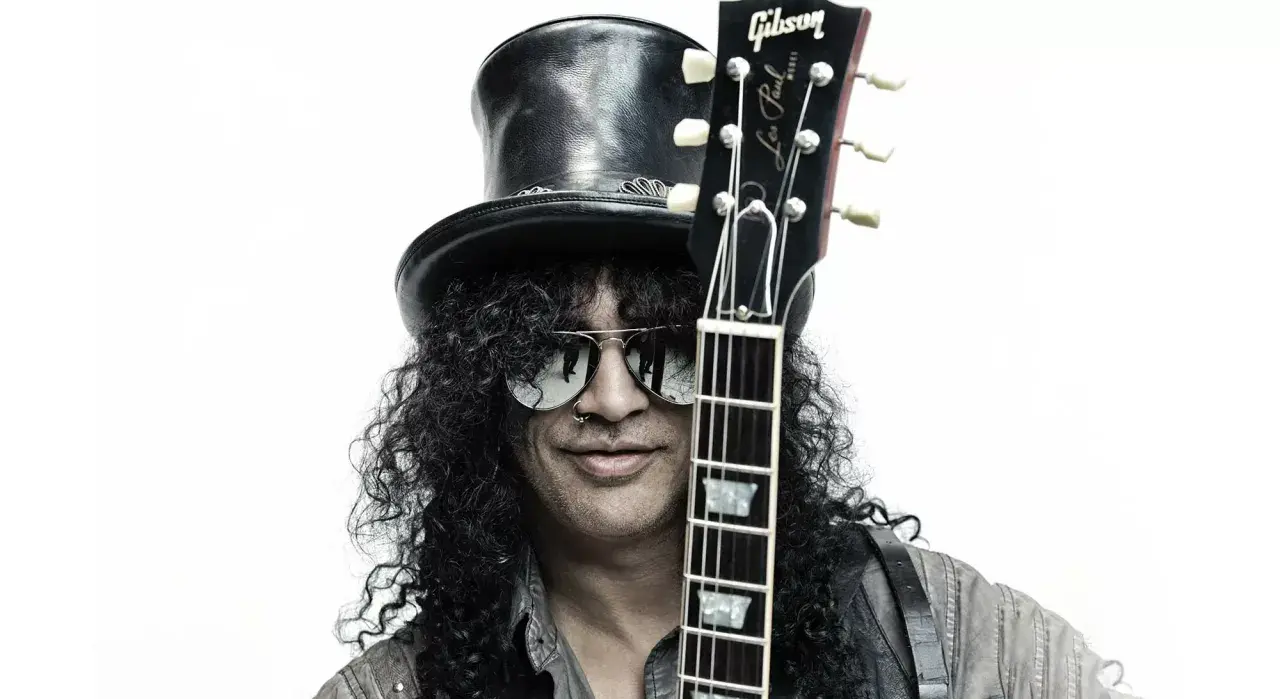 Le guitariste connu Slash, avec son chapeau haut-de-forme et ses lunettes de soleil, tient sa Gibson Les Paul.