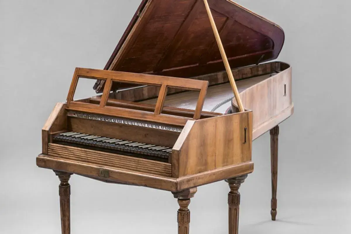 Un clavecin, membre de la famille des instruments à clavier, avec son couvercle ouvert et son pupitre.