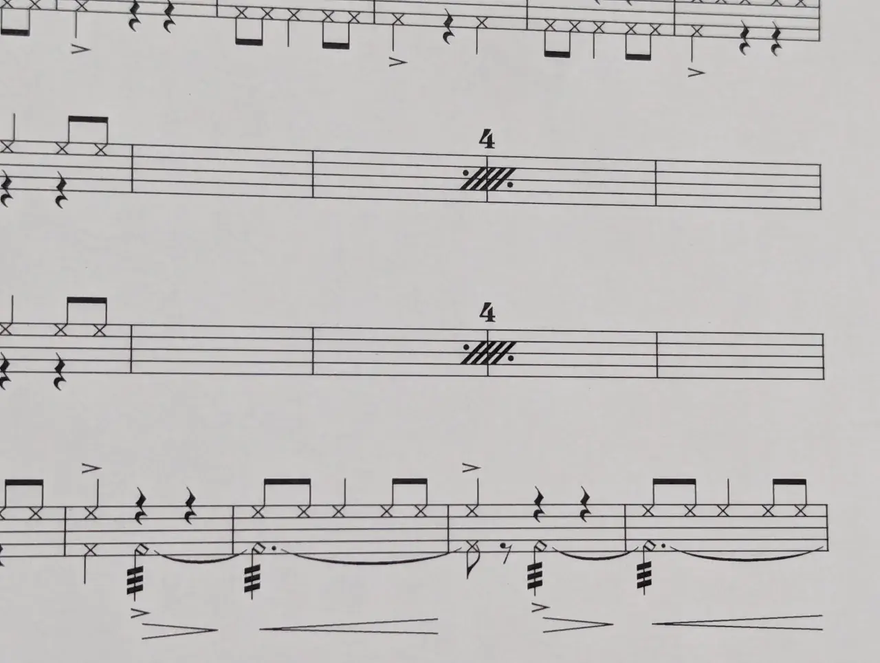 Partitions musicales avec des notes de batterie et des indications de tempo. Le symbole de répétition musique est présent, suggérant une section à rejouer.