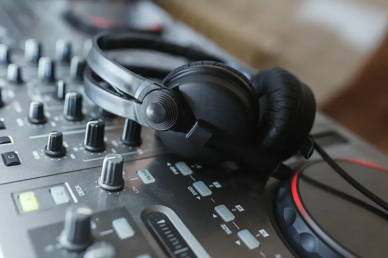 Casque DJ sur une table de mixage, prêt pour le mix. Les boutons et faders, pré et post fader, sont visibles.