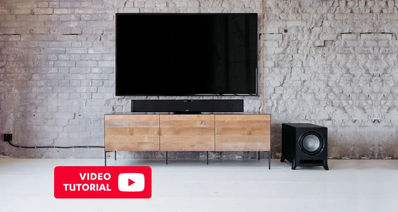 Un salon moderne avec TV, barre de son et caisson de basse. Découvrez où placer caisson de basse pour un son optimal.