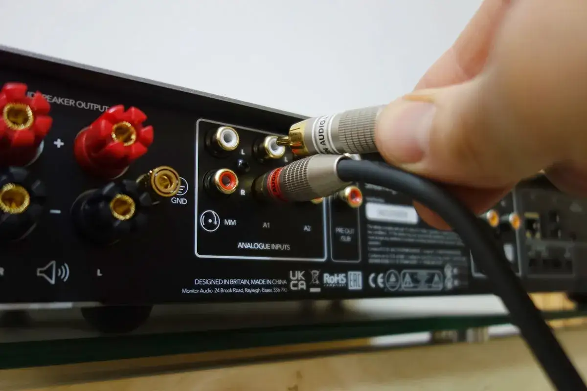 Connexion d'un c&acirc;ble RCA &agrave; une entr&eacute;e analogique d'amplificateur. Un bon damping factor assure une r&eacute;ponse des basses pr&eacute;cise.