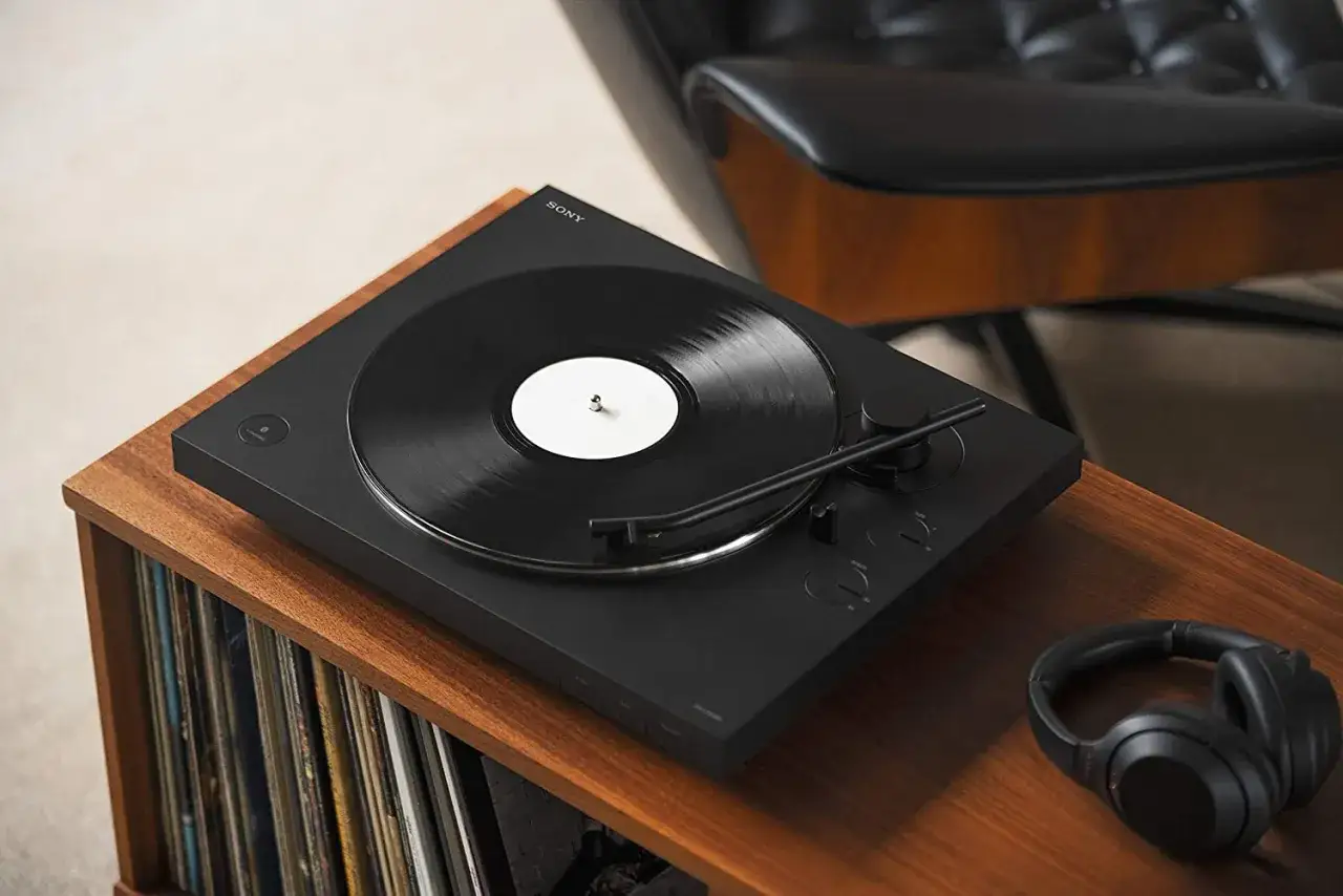 Platine vinyle Sony avec disque noir, prête à enregistrer vinyle sur clé usb. Casque audio à proximité.