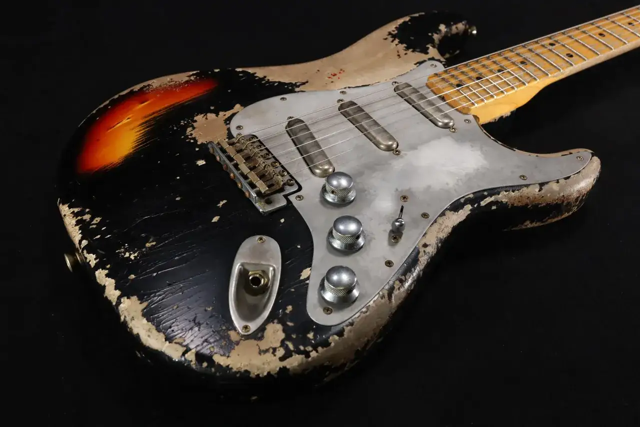 Guitare &eacute;lectrique sunburst avec un aspect vieilli, t&eacute;moignant d'un relicage guitare soign&eacute;.