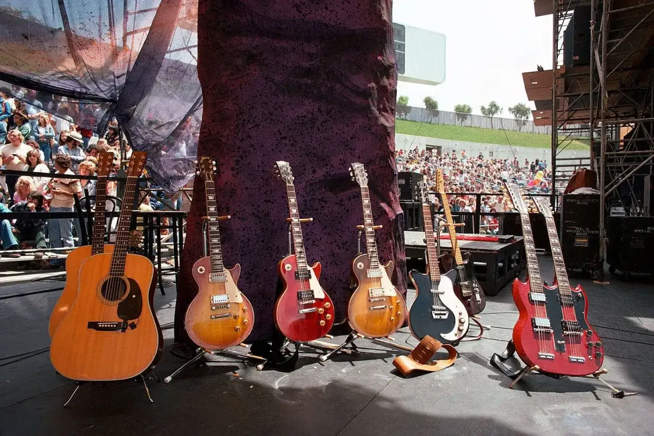 Collection de guitares, dont une guitare acoustique et plusieurs &eacute;lectriques, pr&ecirc;tes pour un concert. On imagine Jimmy Page choisir son instrument.