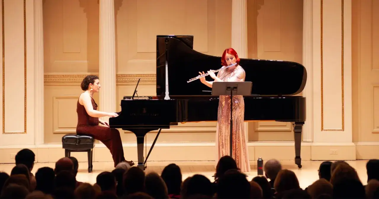 Une fl&ucirc;tiste et une pianiste interpr&egrave;tent de la musique piano classique devant un public.